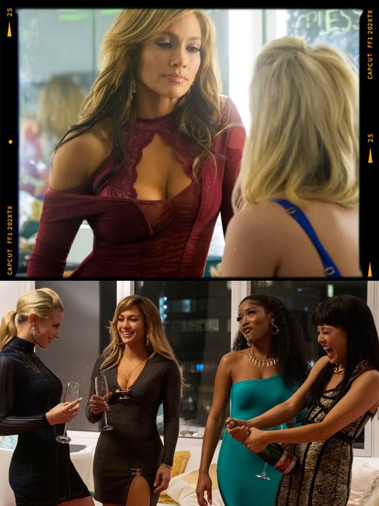 A woman in a burgundy dress interacts with another woman in a stylish outfit in a reflective setting.